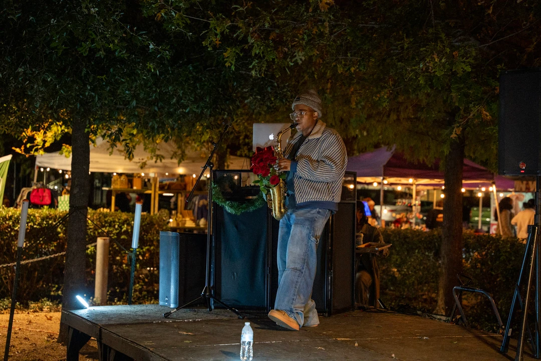 Two musicians perform outdoors beside the evening market.