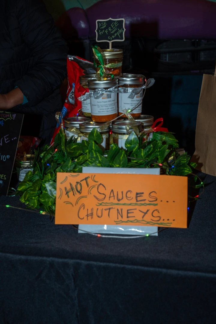 Bottles of hot sauce and a handwritten product sign.