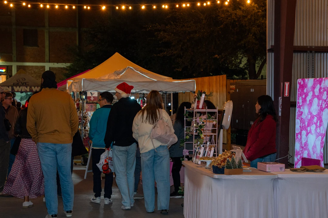 Shoppers browsing stalls beneath warm evening lights.