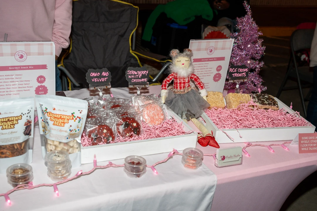 Pink holiday gifts and festive containers on a market display.