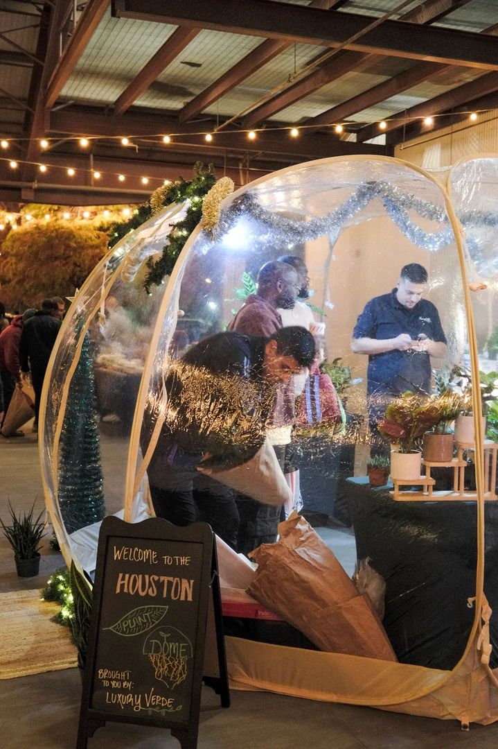 Visitors browsing an illuminated arched market stall.