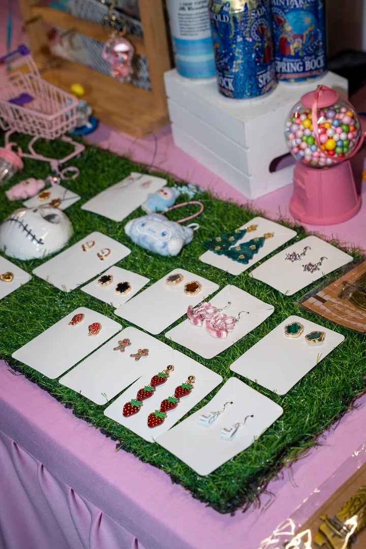 Handmade jewelry displayed on a pink tablecloth.