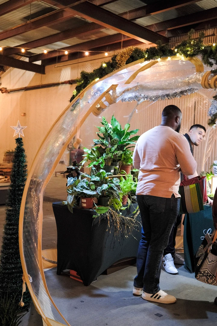 Visitors browsing an illuminated arched market stall.