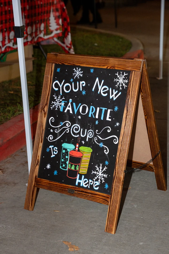 A colorful handwritten welcome sign at a market stall.