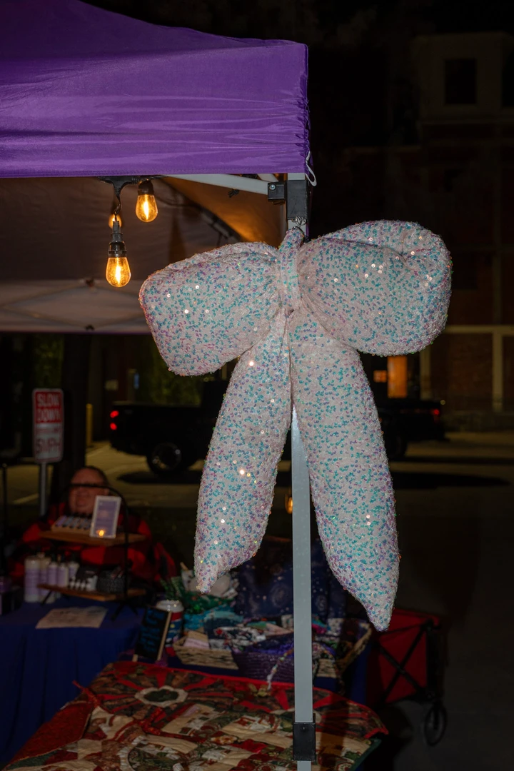 Colorful crocheted flowers and festive decorations at a stall.