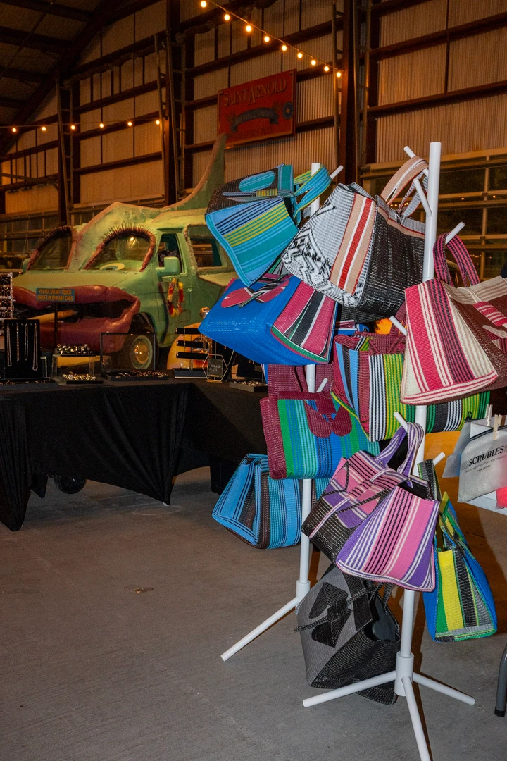 Colorful tote bags displayed at an indoor market stall.