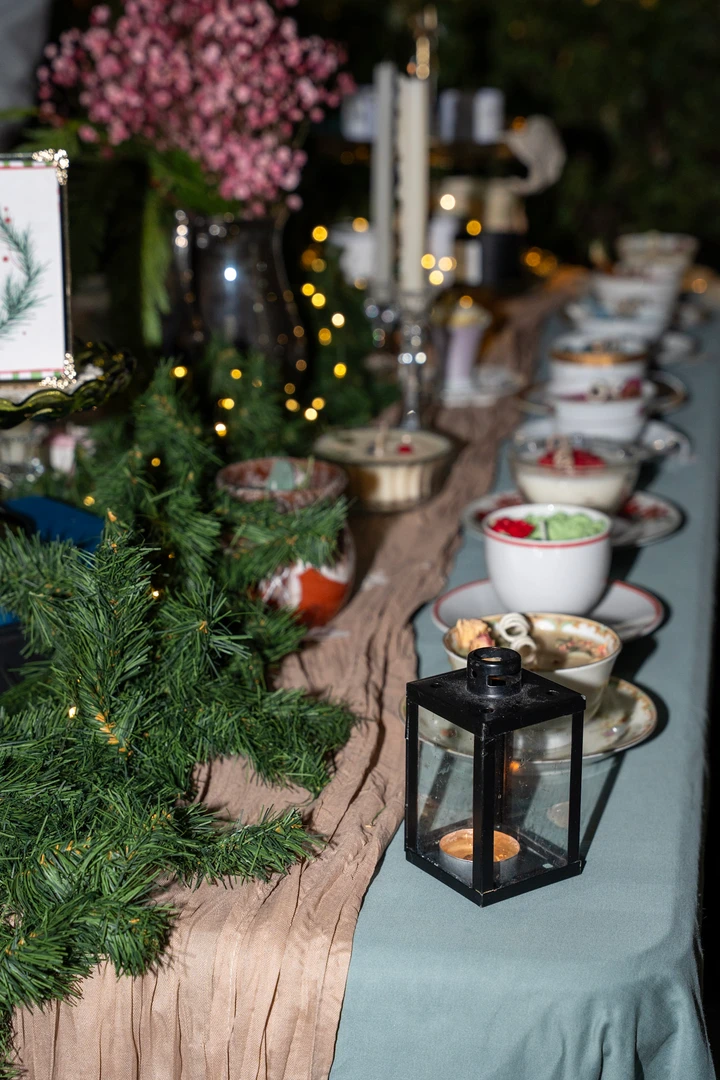 A floral maker and her display of flowers, candles and greenery.