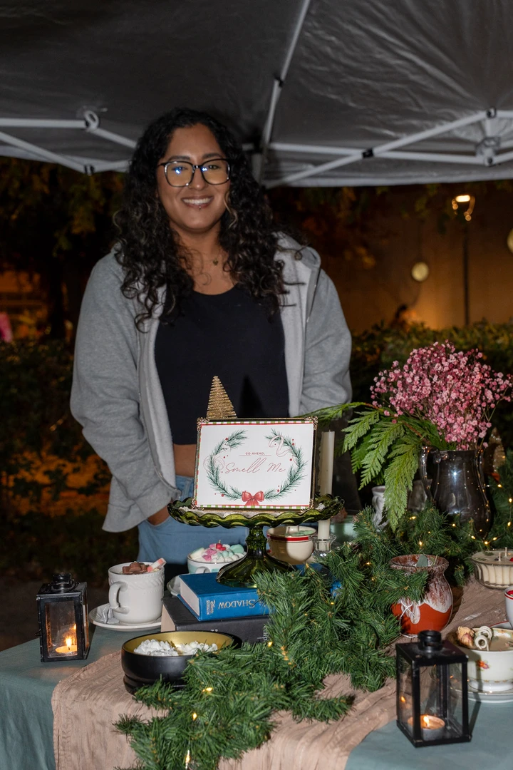 A floral maker and her display of flowers, candles and greenery.