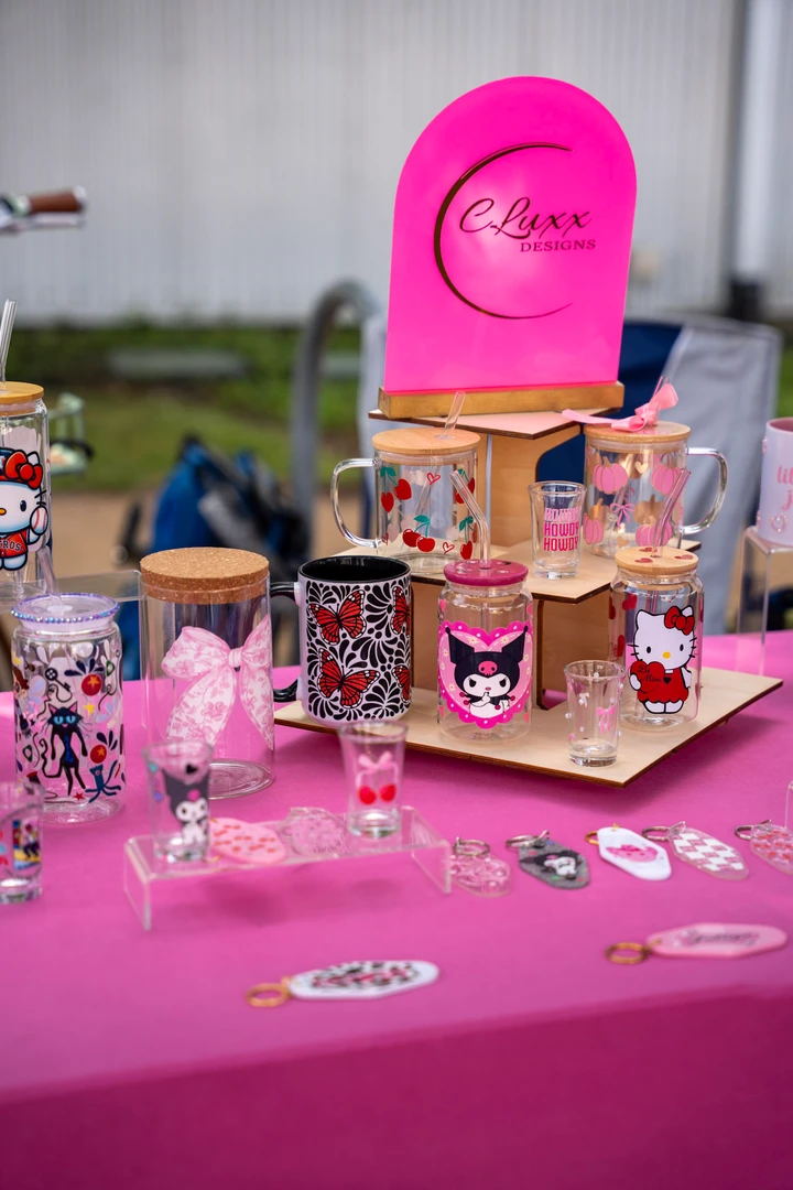 Small jewelry pieces and accessories on a pink display.