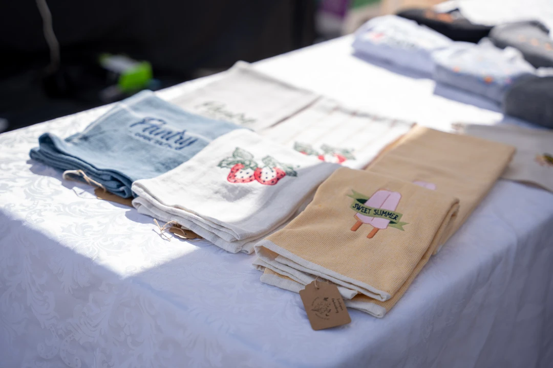 Folded printed shirts on a vendor table.