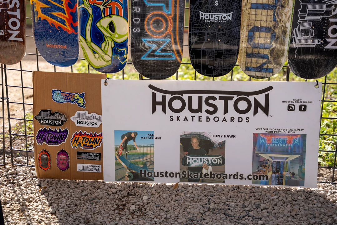 Decorated skateboard decks above a Houston sign.