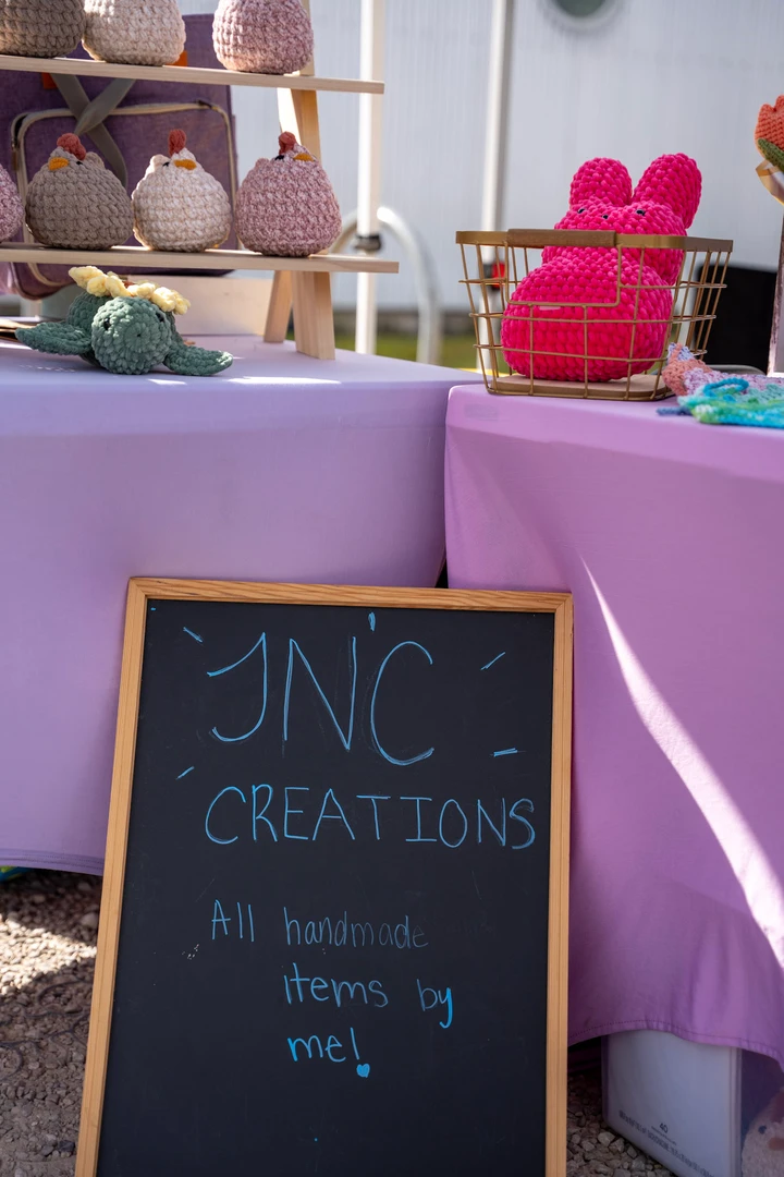 A handwritten creations sign beneath a crochet display.