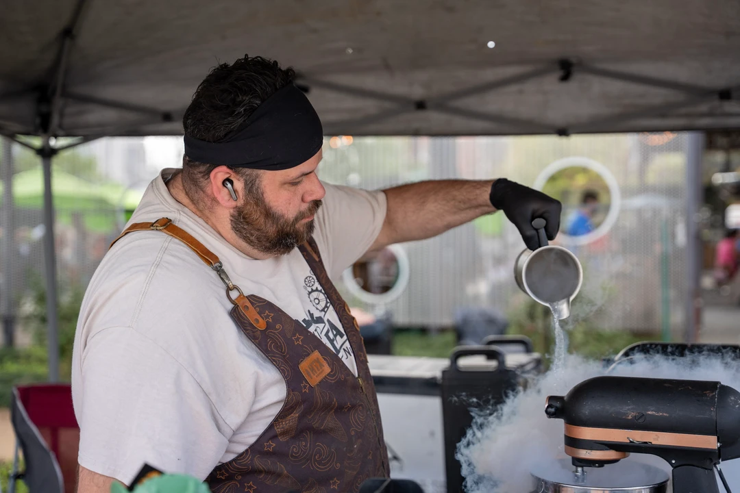 A vendor preparing a drink behind a counter.