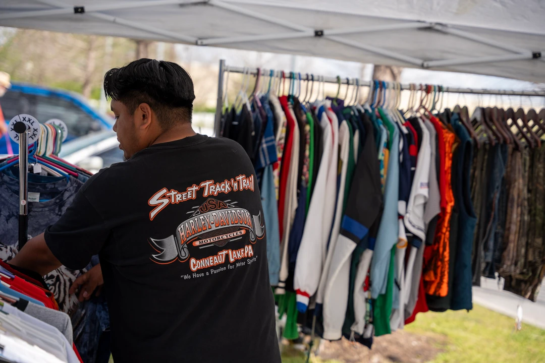 A shopper looking through an outdoor clothing rack.