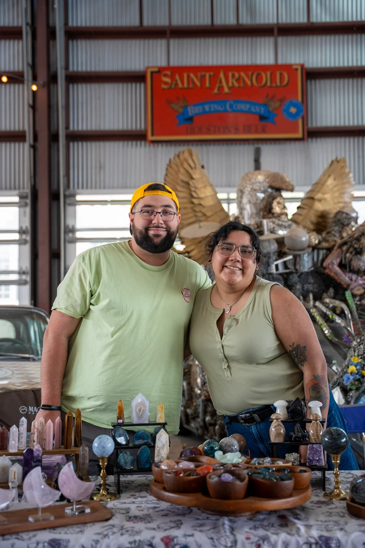 Two makers behind a table of pottery and crafts.