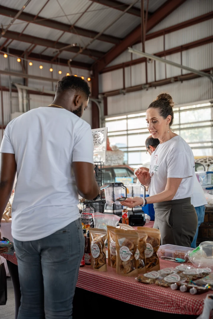 A shopper and vendor talking across a product display.