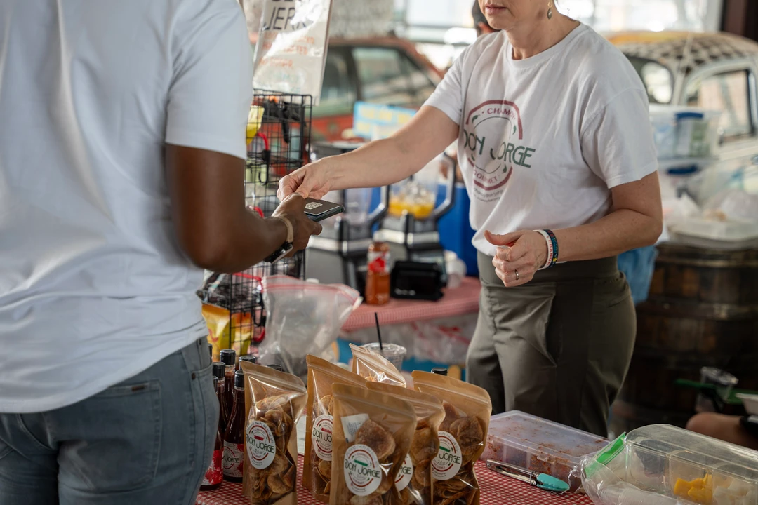 A shopper and vendor talking across a product display.