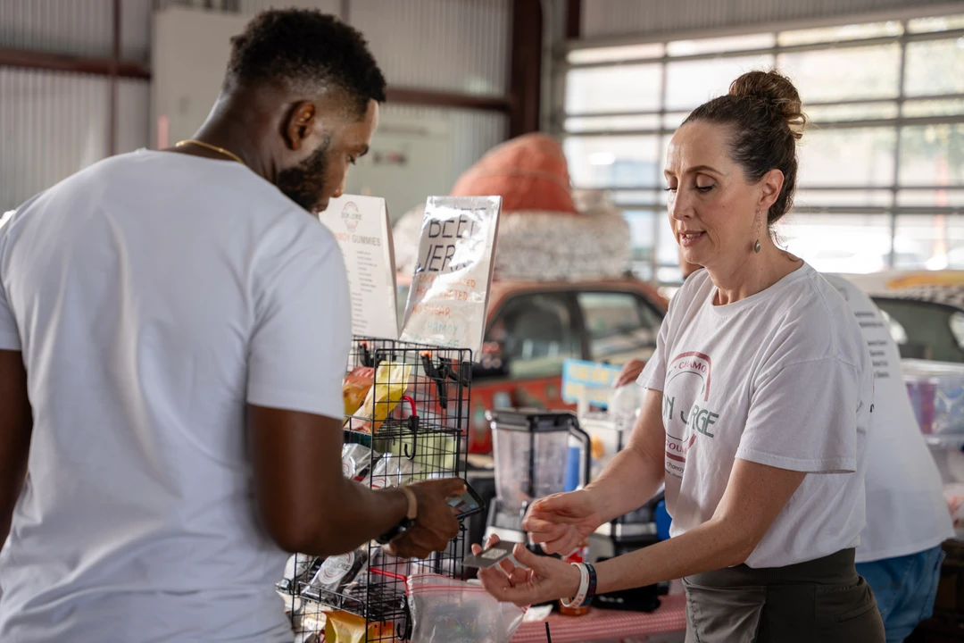 A shopper and vendor talking across a product display.
