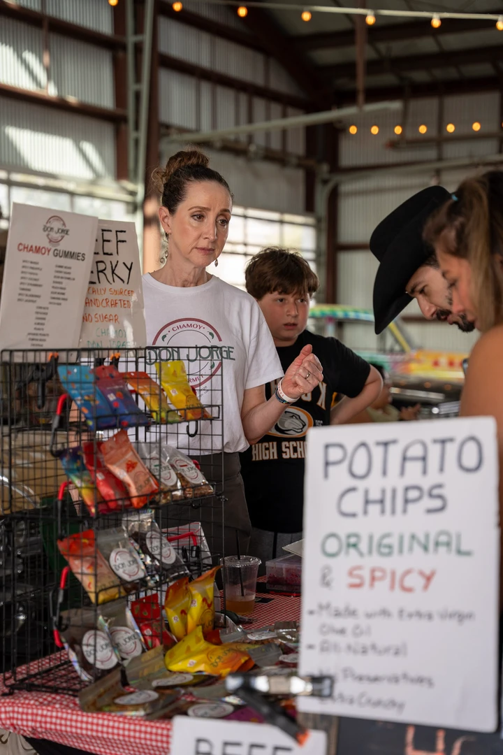 People gathered around a snack stall and potato chip menu.
