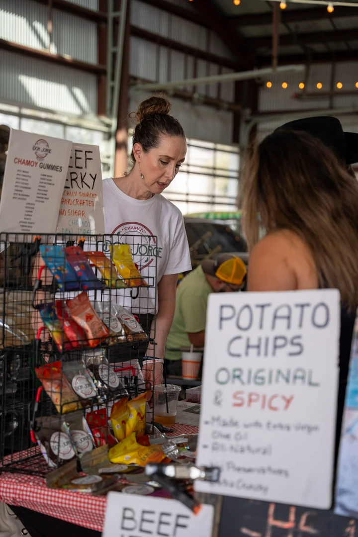 People gathered around a snack stall and potato chip menu.