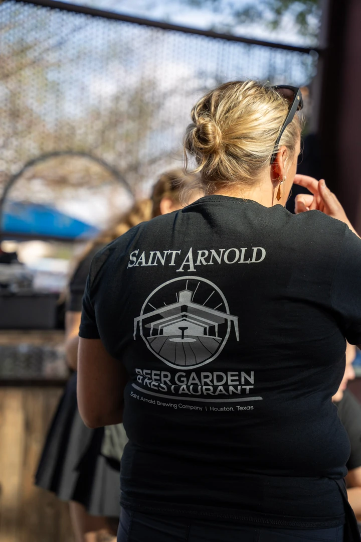 A seated visitor wearing a Saint Arnold shirt.